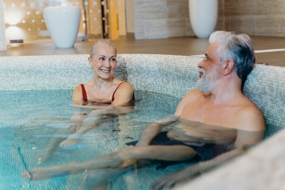 Smiling senior couple relaxing together in an indoor spa pool, enjoying leisure time.